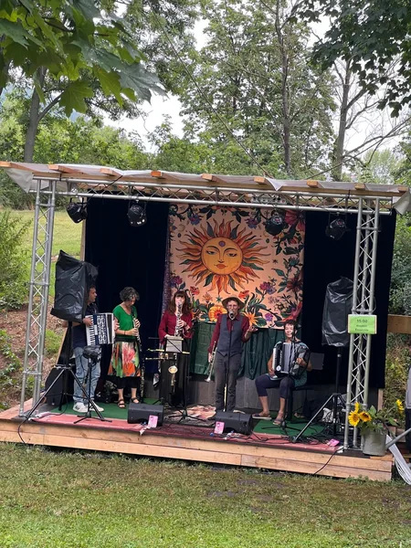 Das Klezmerensemble auf der Bühne unter einer großen Sonne beim Burgauer Folk- und Tanzfest