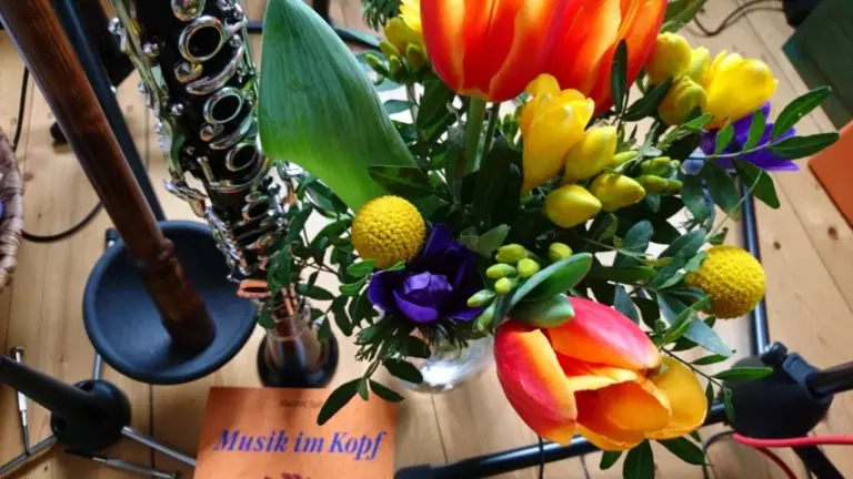 Klarinetten auf einem Ständer neben einem bunten Tulpenstrauß