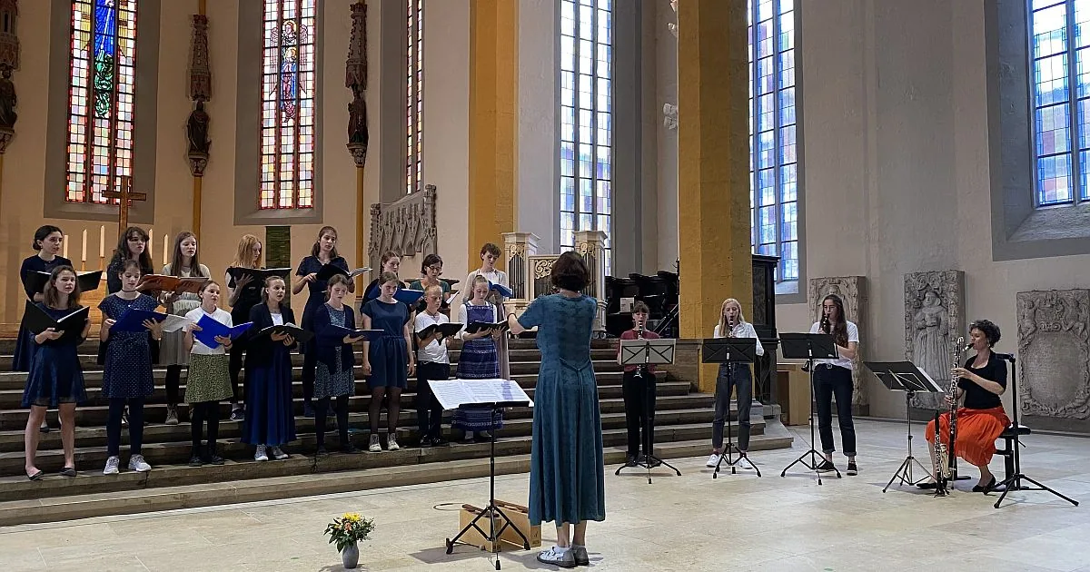 Vokal- und Bläserensemble in einer hohen Kirchenhalle