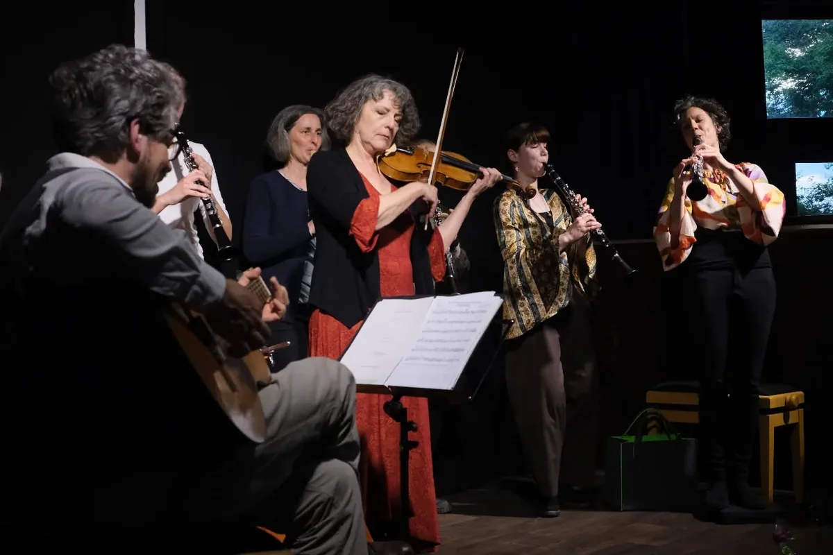 Fünf Musikerinnen und Musiker auf der Bühne, Geige, Klarinetten und Gitarre