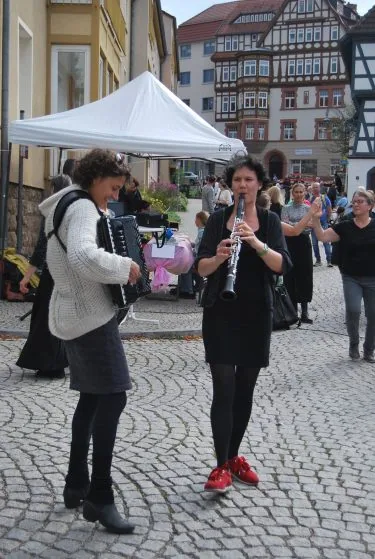 Antje Taubert spielt Klarinette auf dem Marktplatz in Eisenach, daneben tanzt eine Frau