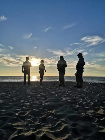 Vier Menschen am Strand von Sylt im Gegenlicht der Morgensonne