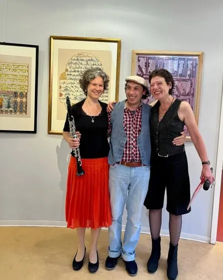 Antje Taubert mit Klarinette, der Künstler Malik Alkhalifa und eine Musikerin vor Kalligrafien