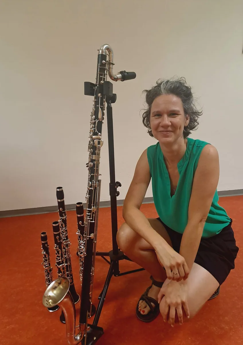Antje Taubert kniet neben fünf aufgestellten Klarinetten und Saxophonen