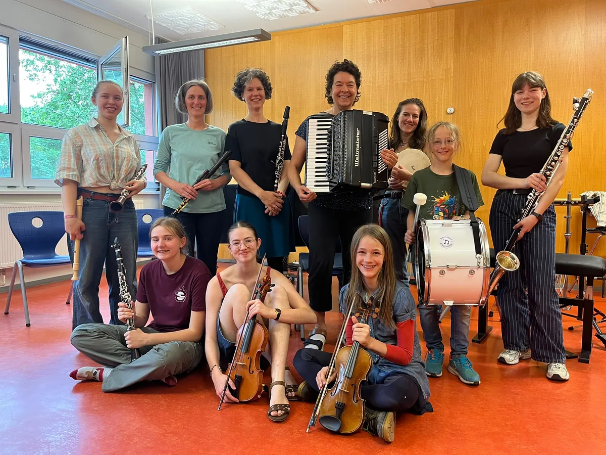 Gruppenbild des Klezmerensembles der Musik- und Kunstschule Jena mit Instrumenten im Probenraum