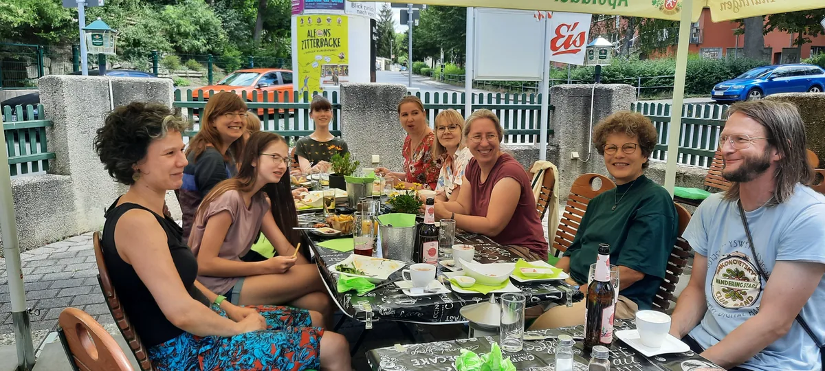 Klezmer-Workshop 2022: Mittagspause an einer langen Tafel im Freien